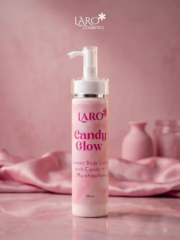 Product photograph: the Candy Glow scented body lotion pump bottle against pink fabric.