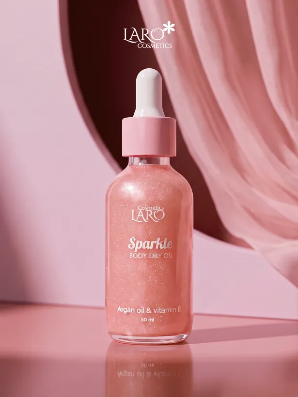 Product photograph: the pink Sparkle body dry oil bottle on pink satin.